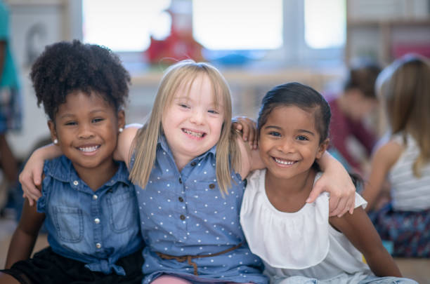 Preschool kids sitting smiling with arms around eachother